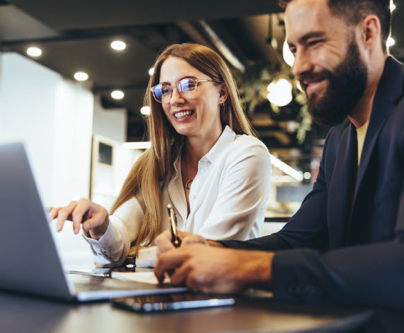 Hombre y mujer jovenes viendo recomendaciones para gestionar facturas en el laptop