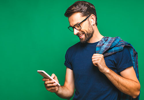 iamgen de hombre sonriendo con un celular en la mano