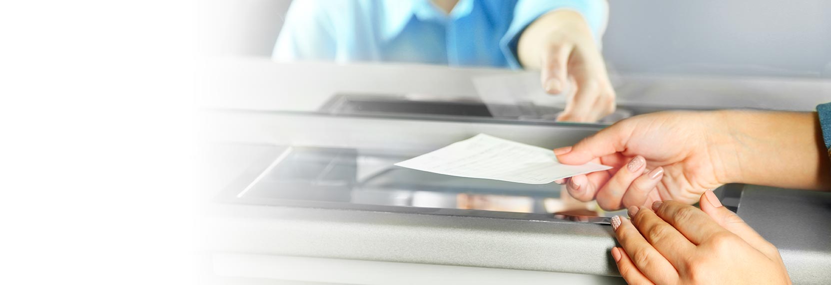 Manos de mujer realizando un pago con un número de validación de pago o PIN en ventanilla del Banco Popular