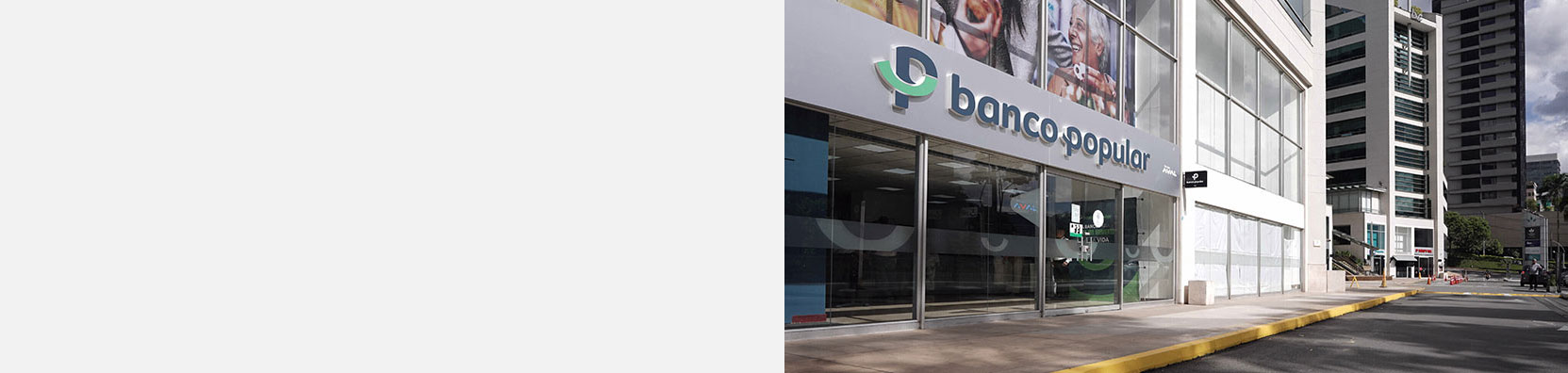 oficinas del Banco Popular con vidrios de cristal y letrero verde con logotipo blanco