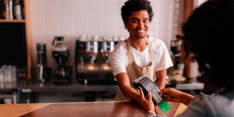 Una mujer está realizando una compra con su tarjeta débito