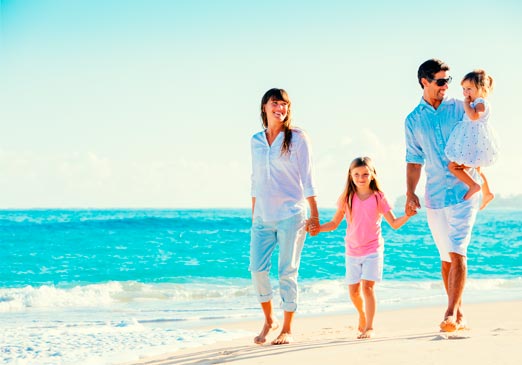 Familia feliz caminando por la playa