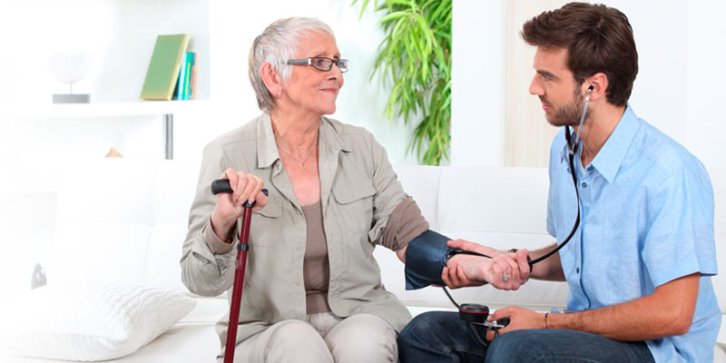 Un medico joven realiza una consulta en su casa a una anciana