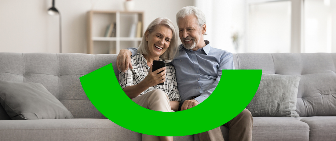 Pareja mayor feliz haciendo transferencias desde su celular