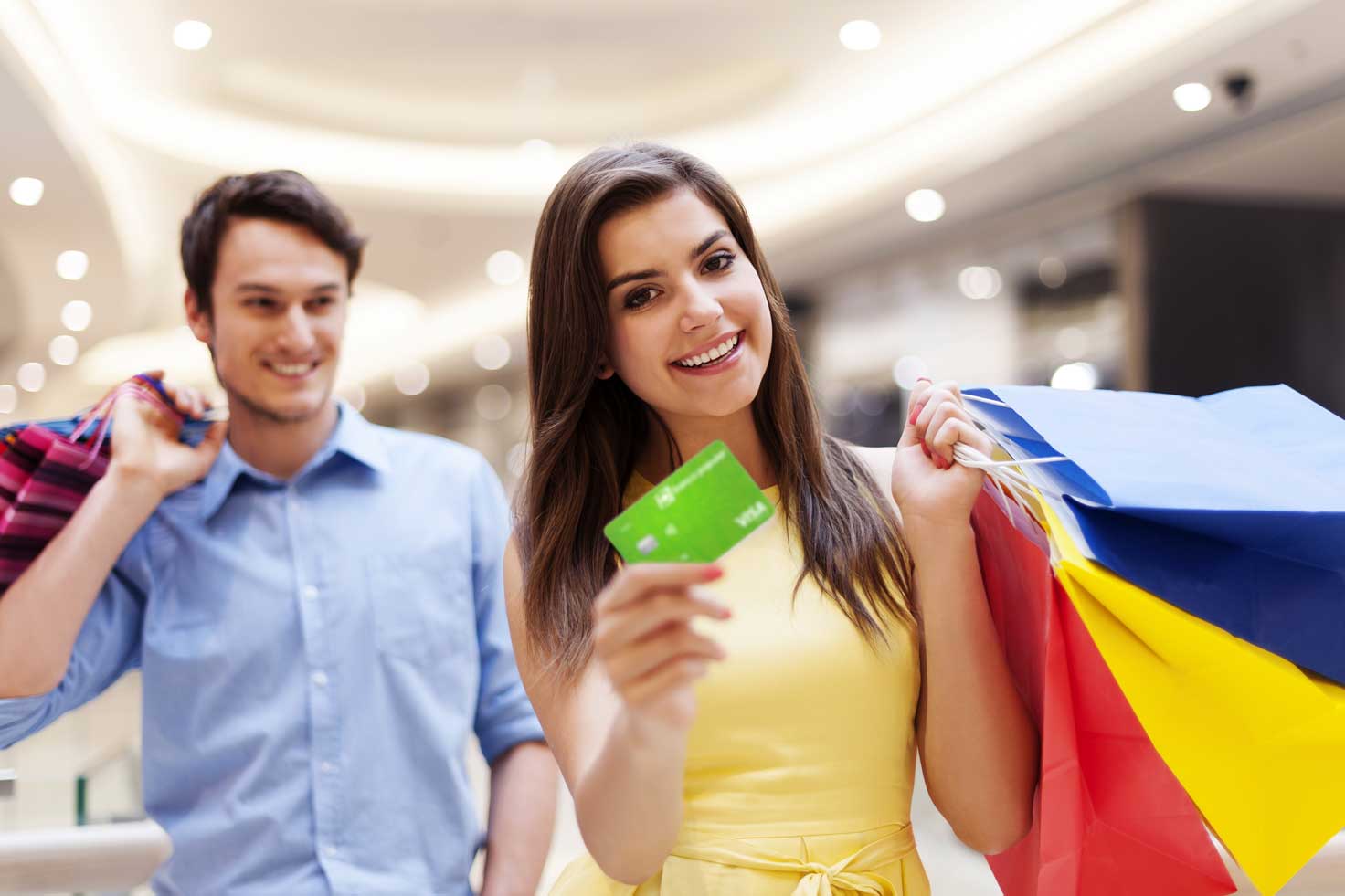 Mujer feliz de compras con su Tarjeta de Crédito Visa Clásica del Banco Popular