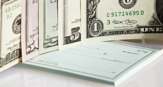 Dolares al costado de una chequera