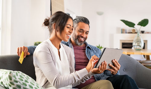 Pareja abriendo su cuenta para Ahorrar del popular en una tablet.