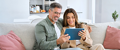 Pareja sonriendo viendo una tablet