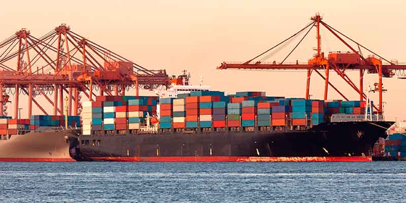 Una barco transportando muchos container de colores con mercancias