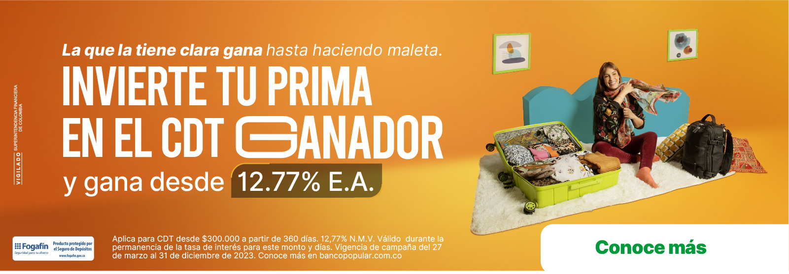 Mujer en su sala feliz empacando prendas en una maleta verde
