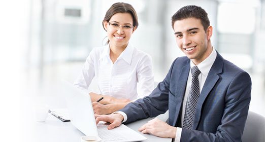Un par de ejecutivos jovenes ingresando al portal empresarial - ICBS Banco Popular desde un computador portátil