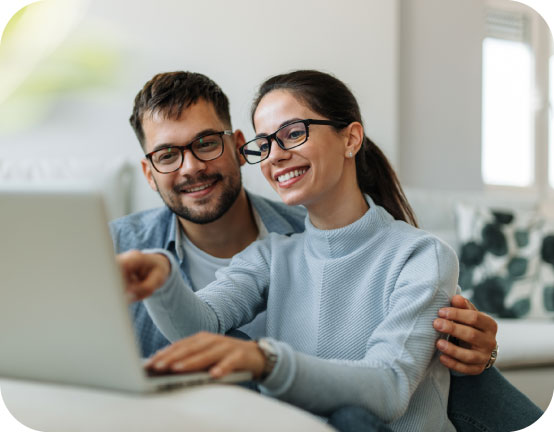 Hombre y mujer sonriendo viendo laptop