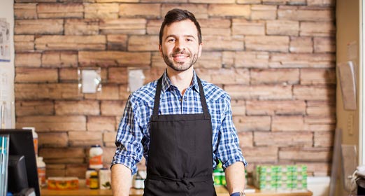 Hombre sonriendo con camisa a cuadros y delantal
