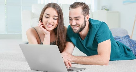 Una pareja utilizando el botón Pse desde un portatil