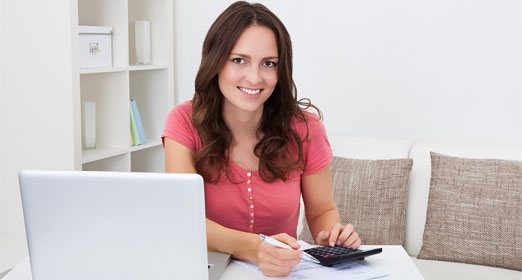Una mujer está haciendo las cuentas de cuanto dinero debe pagar por sus impuestos