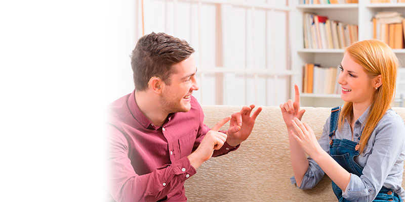 Pareja con discapacidad auditiva comunicandoce con lenguaje de señas