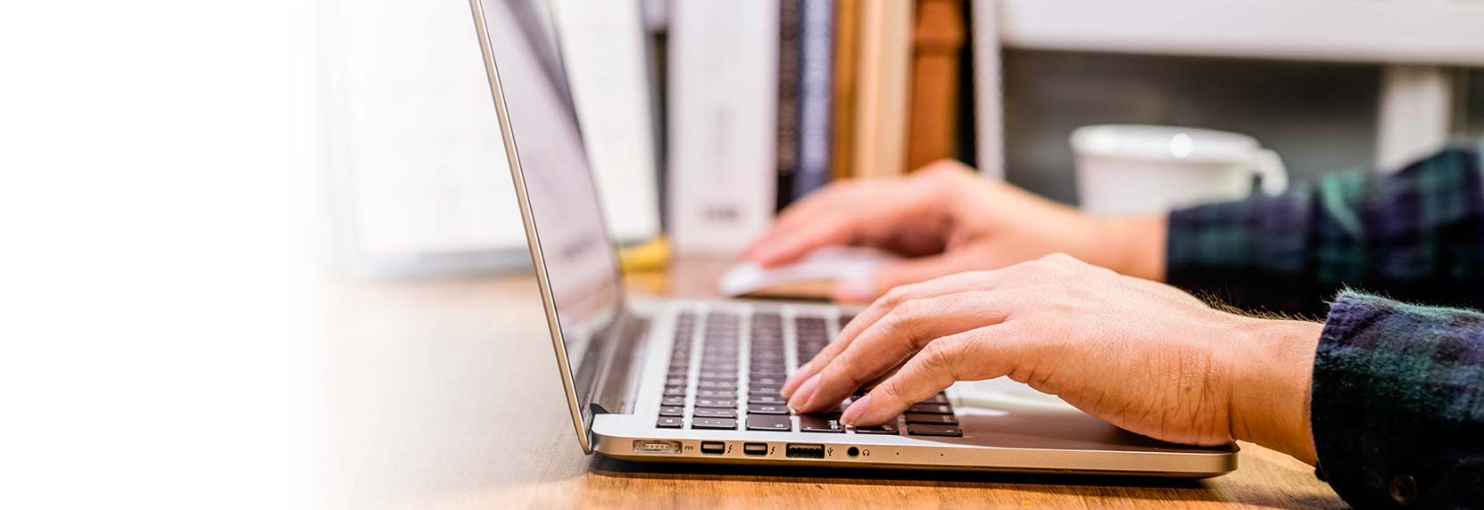 Primer plano de las manos de una persona ingresando sus datos desde su computador portátil