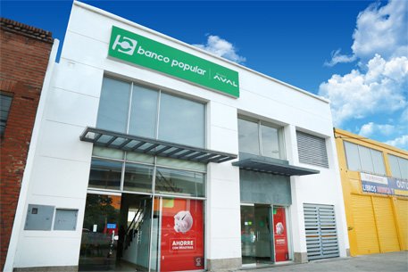 Fachada Exterior de Oficina Banco Popular - paredes blancas - puertas de cristal - logotipo horizontal blanco sobre fondo verde