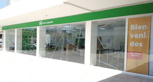 Oficina Banco Popular con puertas de cristal y logotipo en fondo verde y de color blanco