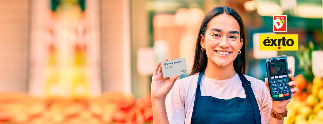 Mujer sonriente con datáfono y tarjeta de creditó del Banco Popular en la mano