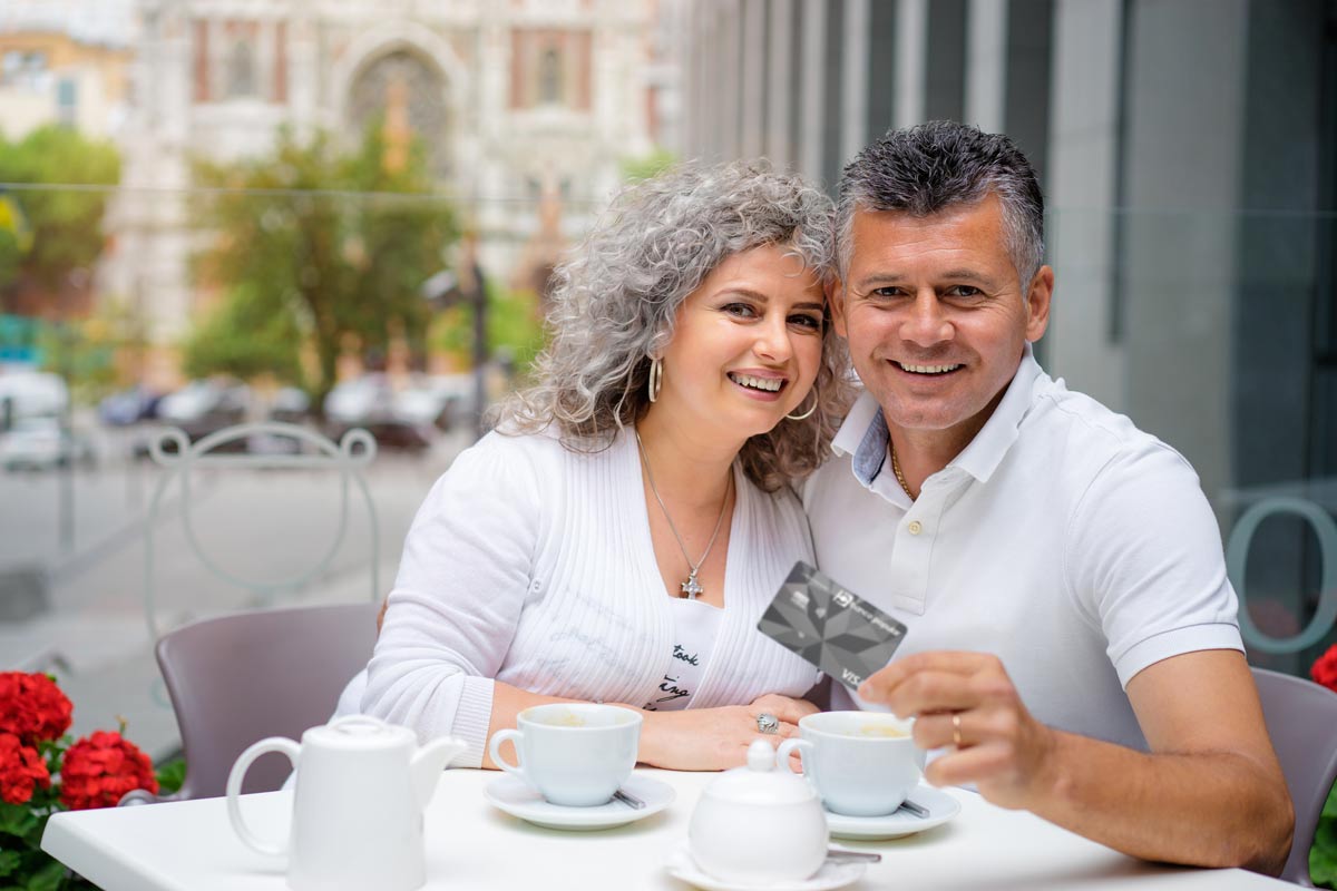 Pareja mostrando su Tarjeta de Crédito Diamante del Banco Popular
