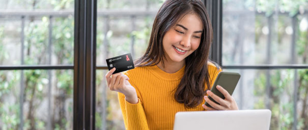 Mujer disfrutando de los beneficios de su tarjeta de crédito LA 14 en su celular