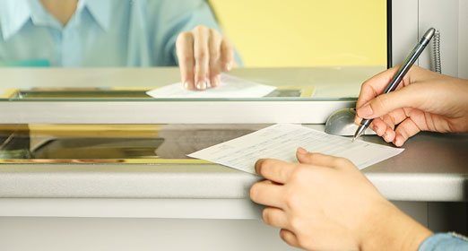 Una persona realizando una consignación en la ventanilla del banco