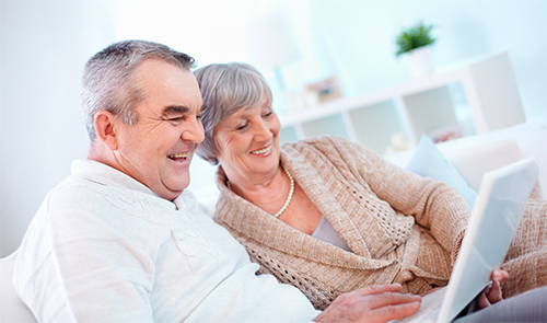 Pareja sonriendo viendo una tablet