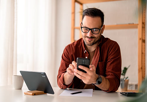 imagen de hombre sonriendo con un celular en la mano