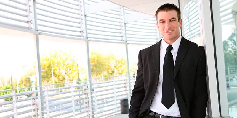Hombre joven de traje negro sonriendo