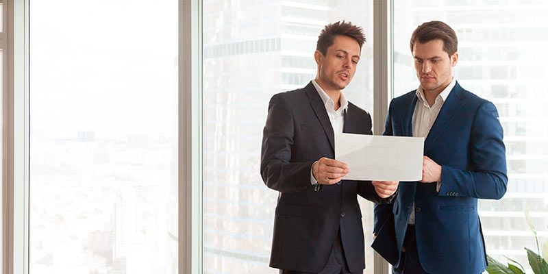 dos empresarios viendo una hoja