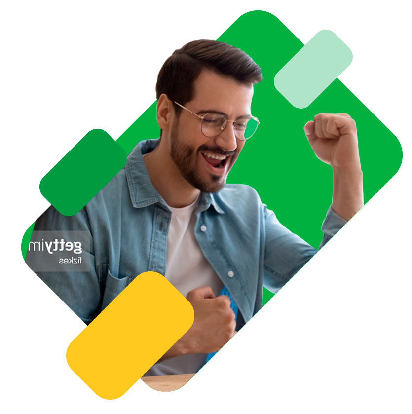 Hombre joven de barba y camisa azul sonriendo con el puño en alto