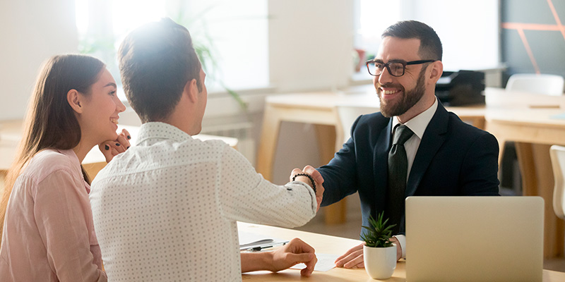 Un cliente y un ejecutivo financiero sonriendo