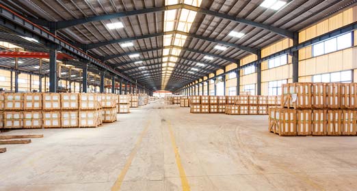 Una bodega muy grande con varias estibas de madera y cajas