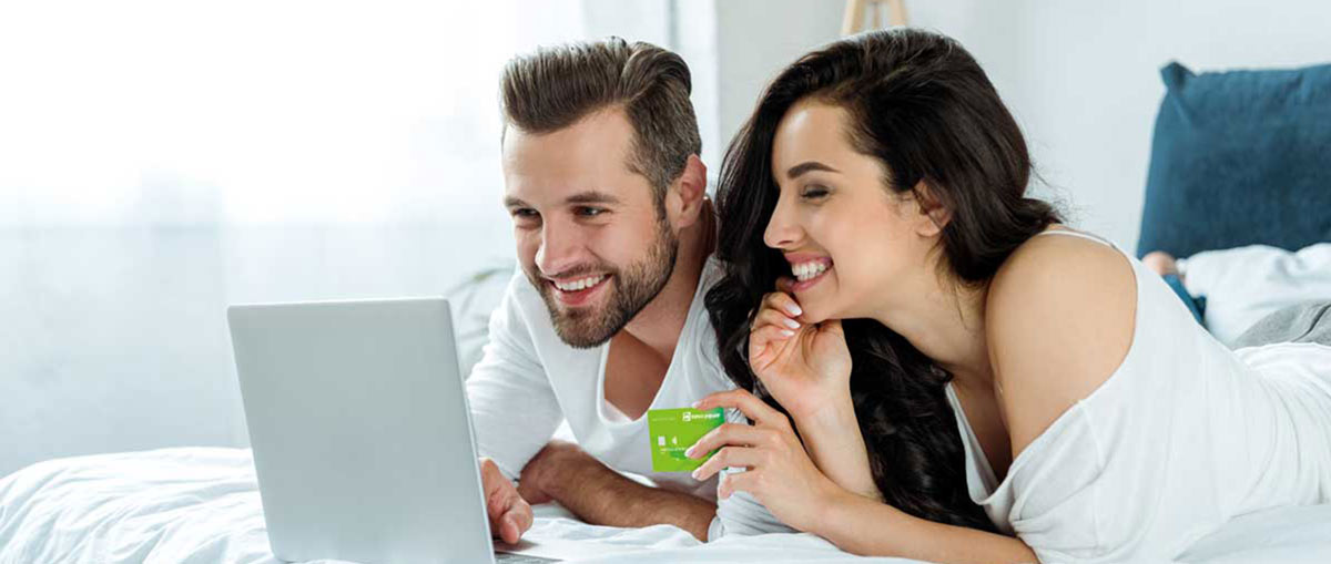 Hombre y mujer con Tarjeta Débito consultando en internet